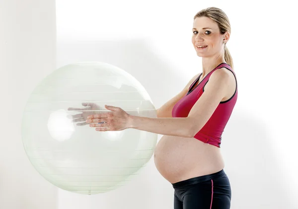 Portret van zwangere vrouw doen oefeningen met een bal — Stockfoto