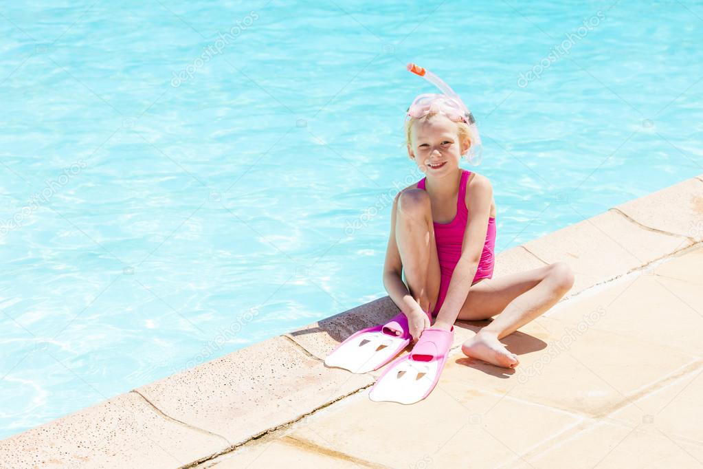 Girl with snorkeling equipment at swimming pool