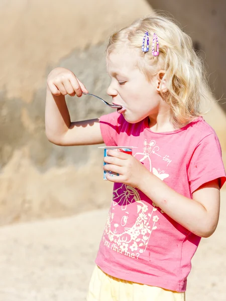 Little girl eating yogurt — Stock Photo, Image