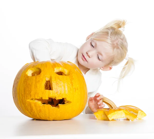 Liten flicka snidning pumpa till halloween — Stockfoto