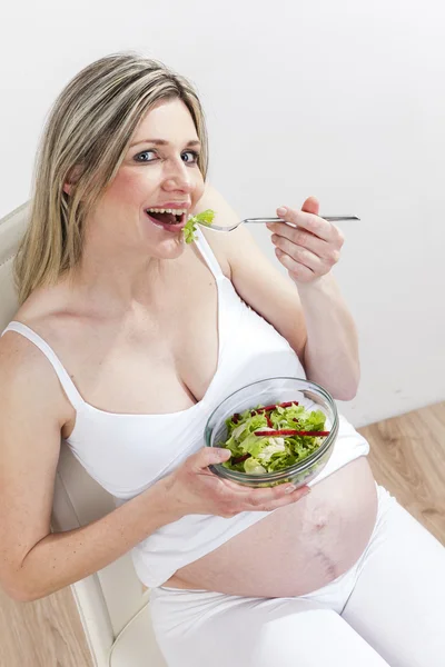 野菜のサラダを食べる妊娠中の女性の肖像画 — ストック写真