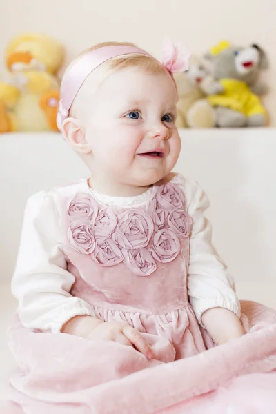 Portrait of sitting toddler girl wearing pink dress — Stock Photo, Image