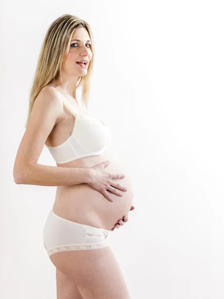 Retrato de mujer embarazada de pie usando lencería —  Fotos de Stock