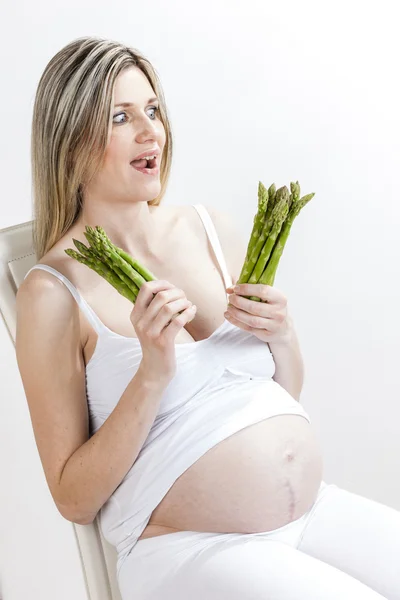 Yeşil kuşkonmaz tutan hamile kadın portresi — Stok fotoğraf