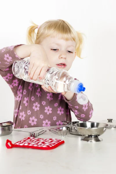 Liten flicka leker med barn maträtt — Stockfoto