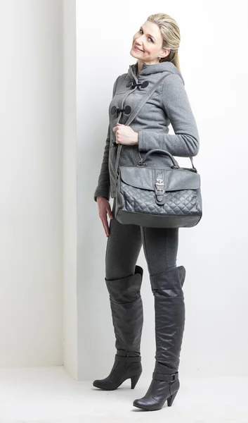 Femme portant des vêtements gris avec un sac à main — Photo