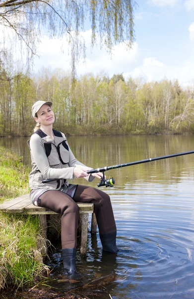 Mujer pescando en muelle en estanque —  Fotos de Stock