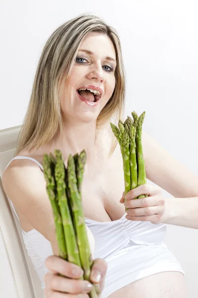 Retrato de mujer embarazada sosteniendo espárragos verdes — Foto de Stock