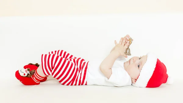 Baby flicka som jultomten innehar en klocka — Stockfoto