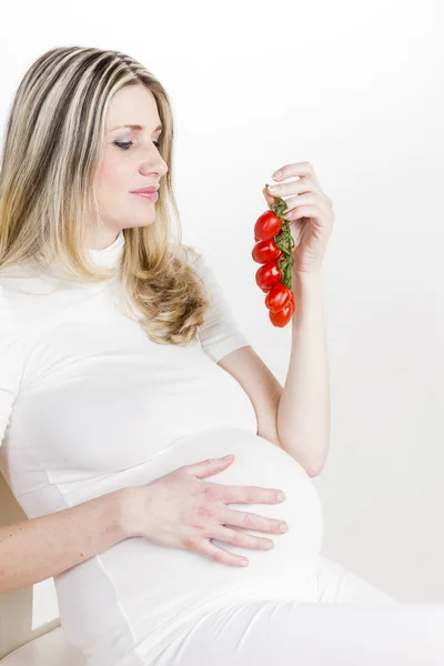 Retrato de mulher grávida segurando tomates — Fotografia de Stock