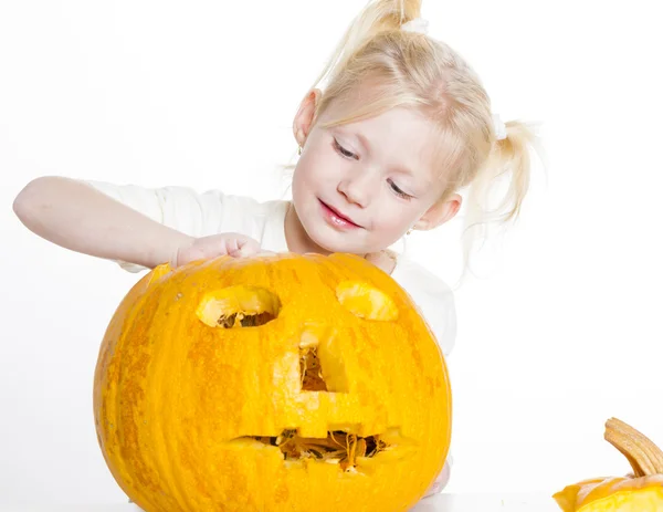 Liten flicka snidning pumpa till halloween — Stockfoto