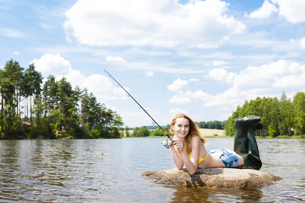 Mladá žena ryby v rybníku v létě — Stock fotografie