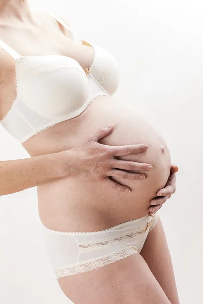 Närbild på stående gravid kvinna bär underkläder — Stockfoto