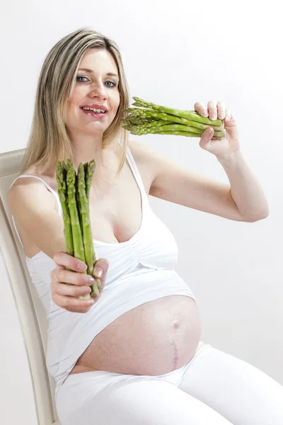 Retrato de mulher grávida segurando espargos verdes — Fotografia de Stock