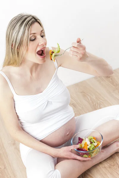 Portrait de femme enceinte mangeant de la salade de légumes — Photo