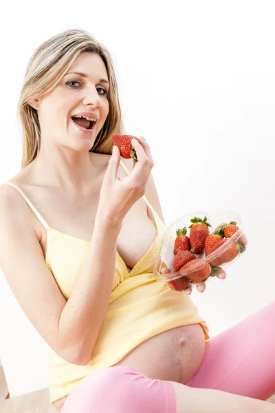 Retrato de la mujer embarazada comiendo fresas — Foto de Stock