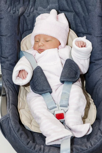 Pasgeboren babymeisje in een autostoel — Stockfoto