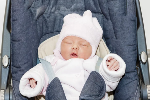 Portrait of newborn baby girl in a car seat — Stock Photo, Image