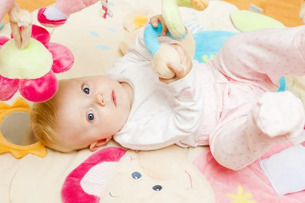 Meisje van de baby liggend op de mat spelen — Stockfoto