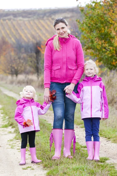 Mother and her daughters in autumnal nature — Stock Photo, Image
