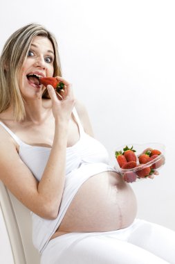 Hamile kadın çilek yiyor.