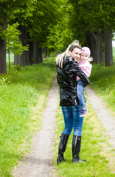 Mother with her little daughter in spring alley — Stock Photo, Image
