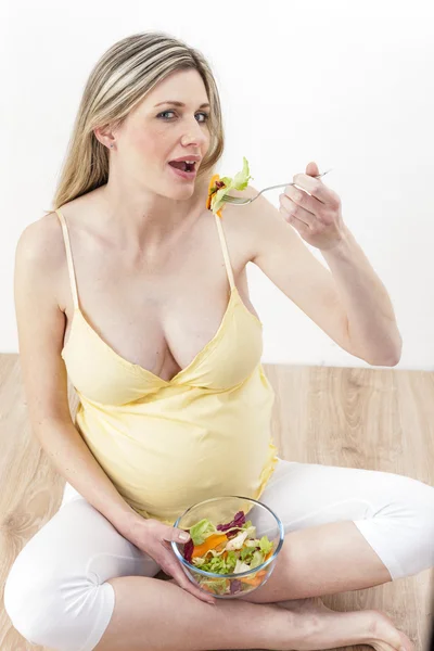 Mulher grávida comendo salada de legumes — Fotografia de Stock