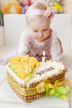yürümeye başlayan çocuk kız onun doğum günü pastası ile oturan
