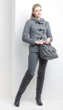 bir çanta ile gri elbise giyen kadın