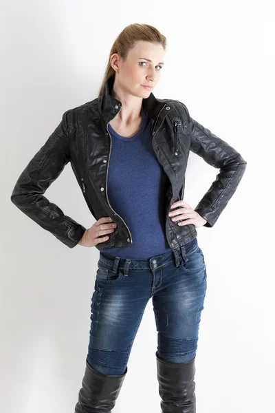 Porträtt av stående kvinna klädd i jeans och svart jacka — Stockfoto