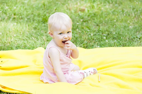 Kleinkind Mädchen in rosa Kleid sitzt auf Decke — Stockfoto