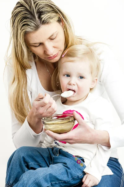 Портрет матери, кормящей свою маленькую дочь — стоковое фото