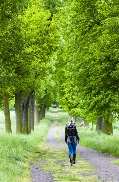 Femme portant des bottes en caoutchouc marchant dans l'allée du printemps — Photo