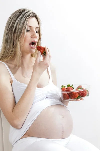 Mulher grávida comendo morangos — Fotografia de Stock