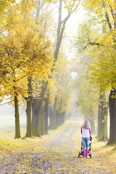 Kvinna med barnvagn på promenad — Stockfoto