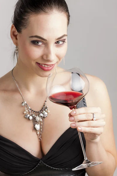 Portrét mladé ženy se sklenicí červeného vína — Stock fotografie