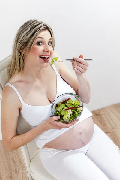Беременная женщина ест овощной салат — стоковое фото