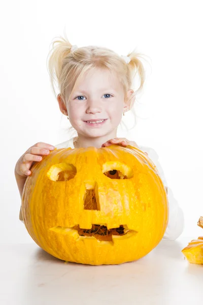 Liten flicka snidning pumpa till halloween — Stockfoto