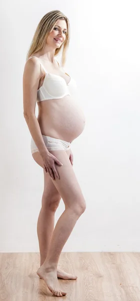 Standing pregnant woman wearing lingerie — Stock Photo, Image