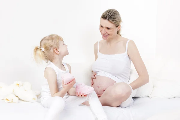 Kleines Mädchen und ihre schwangere Mutter — Stockfoto