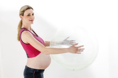 Hamile bir kadın topla egzersiz yapıyor.