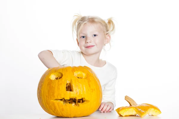 Liten flicka snidning pumpa till halloween — Stockfoto