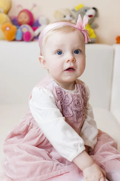 Portret siedzący toddler dziewczynka noszenie różowa sukienka — Zdjęcie stockowe