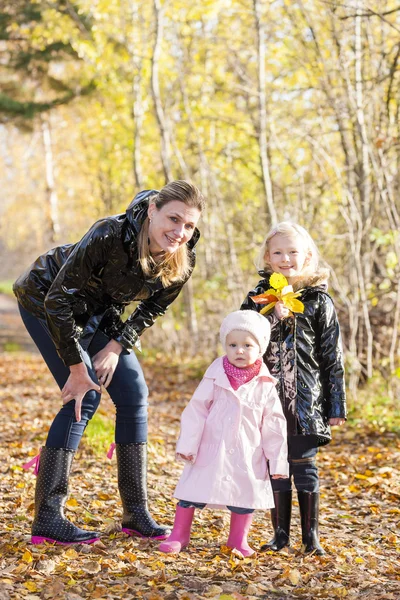 Mother with her daughters in autumnal nature — Stock Photo, Image