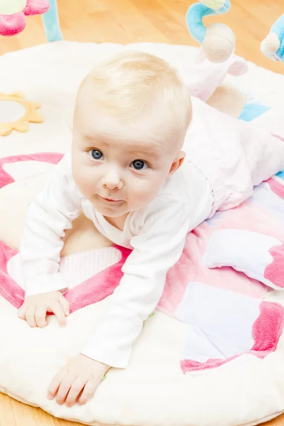 Niña acostada en una alfombra de juego —  Fotos de Stock