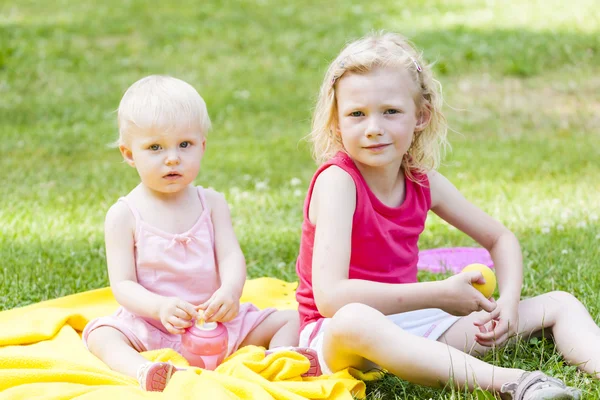Kleine Mädchen sitzen auf einer Decke — Stockfoto