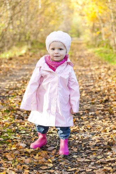 Liten flicka klädd i gummi stövlar i höstliga naturen — Stockfoto