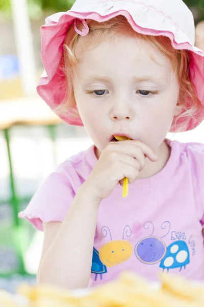 Kleines Mädchen isst Chips — Stockfoto