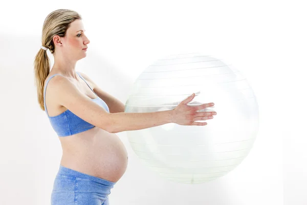 Gravid kvinna gör övningar med en boll — Stockfoto