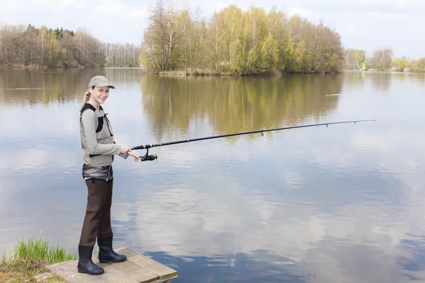 Woman fishing on pier at pond — Stock Photo, Image